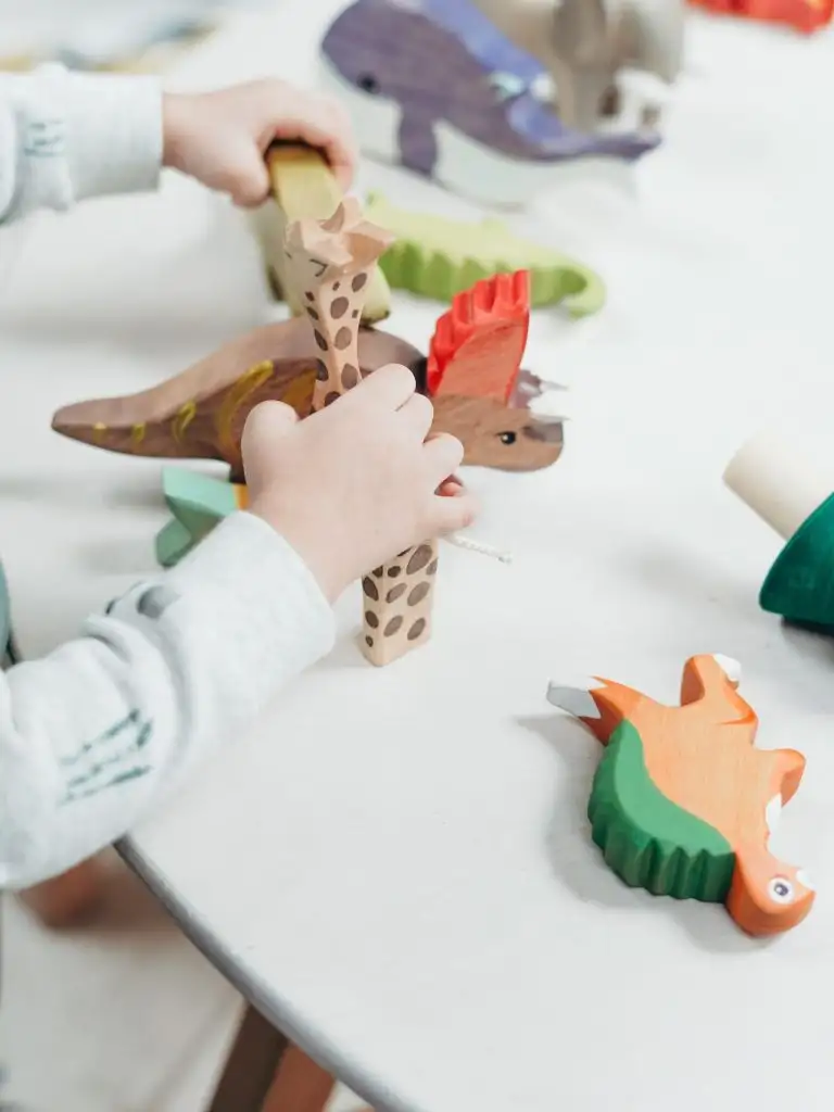 Kind spielt mit Dinosaurier